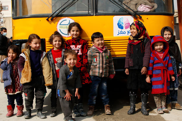 Charmaghz children in front a bus