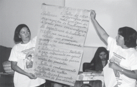 Two women holding up notes collecting from meetings