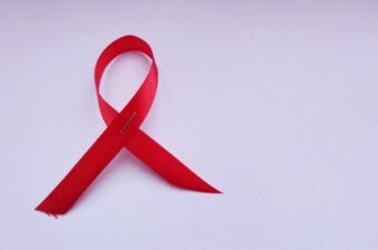 A red aids ribbon over a white background