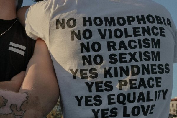 Man wearing t-shirt with both anti-discrimination and positive action messages