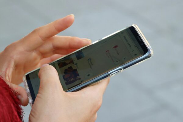 Cropped image of hands holding a cell phone looking at a map
