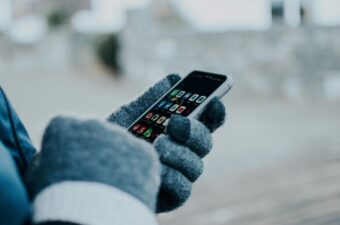 Hands holding a phone looking at the apps on screen