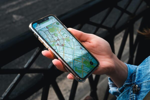 Hand holding a mobile phone with a map on it